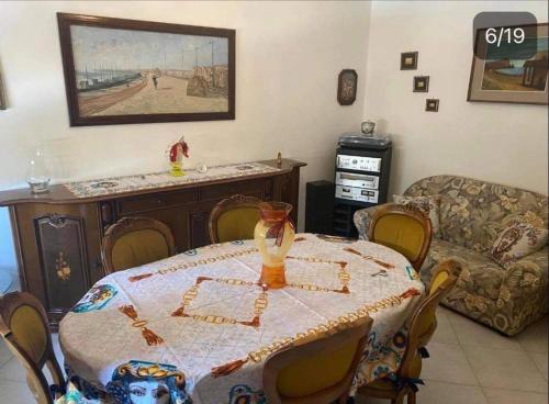 a living room with a table and a couch at Marsala beddra lu suli, lu Mari e lu ventu in Marsala