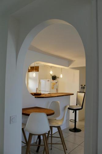 une cuisine et une salle à manger avec une table et des chaises dans l'établissement L'annexe App'Art, à Sète