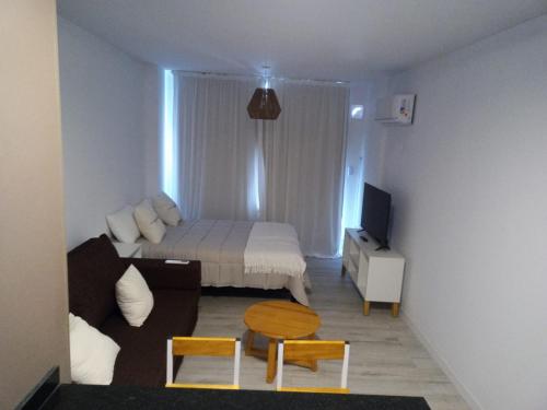 Habitación pequeña con cama y sofá en Paraguay Curt en Rosario