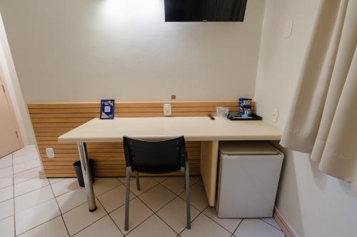 a desk with a chair in a small room at Hotel Caiuá Express Umuarama in Umuarama