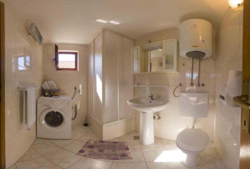 a white bathroom with a sink and a toilet at Apartment s Jukica in Vis