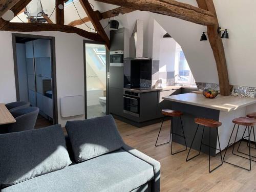un salon avec un canapé et une cuisine dans l'établissement Le Henri IV - Vue Cathédrale, Parking, à Rouen