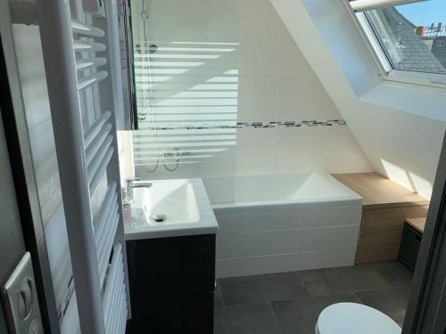 a white bathroom with a sink and a bath tub at Le Henri IV - Vue Cathédrale, Parking in Rouen