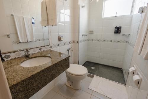 biała łazienka z umywalką i toaletą w obiekcie Hotel Caiuá Express Umuarama w mieście Umuarama