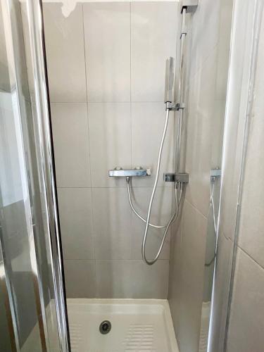 une salle de bain avec une douche avec une porte vitrée dans l'établissement Appartement T2 Corte Centre Ville, à Corte