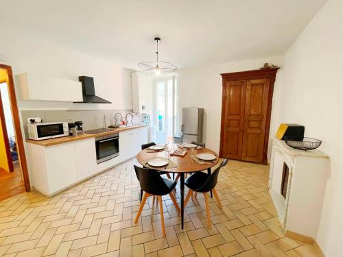 une cuisine avec une table et des chaises dans une pièce dans l'établissement Appartement T2 Corte Centre Ville, à Corte