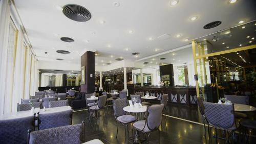 a restaurant with tables and chairs and a bar at Hotel Presidente Buenos Aires in Buenos Aires