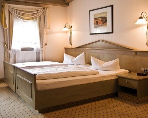 a bedroom with a large bed in a room at Hotel DREI SCHWANEN - Ristorante Due Fratelli in Hohenstein-Ernstthal