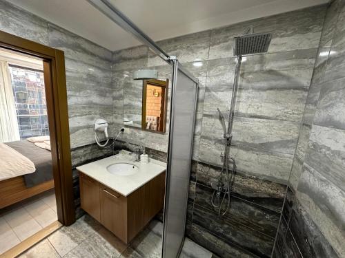 uma casa de banho com um chuveiro e um lavatório. em Vera Suite Hotel Trabzon em Trebizonda