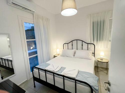 1 dormitorio con cama blanca y ventana en Twins Apartments, en Fanari