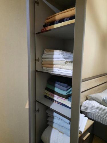 a closet with folded towels and a bed at Apartament - Axis palace saburtalo in Tbilisi City