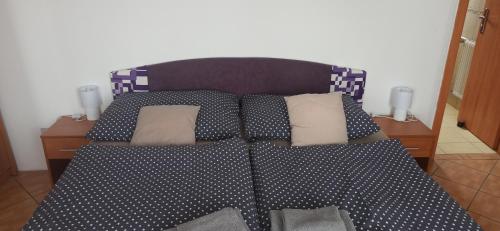 a bed with black and white sheets and pillows at Penzion Forest in Rozvadov