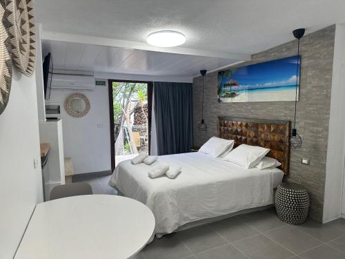 1 dormitorio con cama, mesa y ventana en Apartamentos Finca Wapa en Frontera