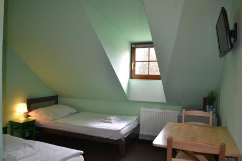 テルチにあるホテル アントンのベッド2台と窓が備わる小さな客室です。
