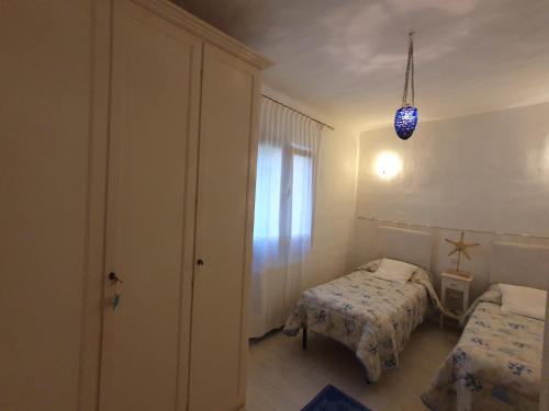 a small bedroom with two beds and a window at Casa vacanza in riva al mare in Arzachena