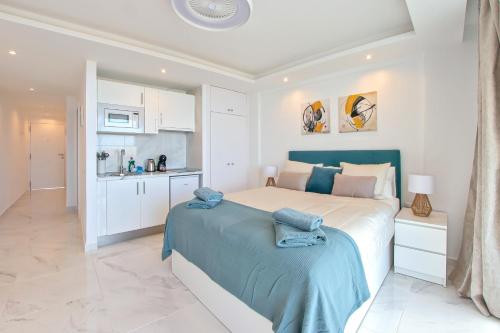 a white bedroom with a large bed and a kitchen at Buena Vista Ponderosa 517 in Playa Fañabe