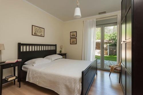 a bedroom with a bed and a sliding glass door at Stellar Villa Private Pool-Sea View in Porto Heli