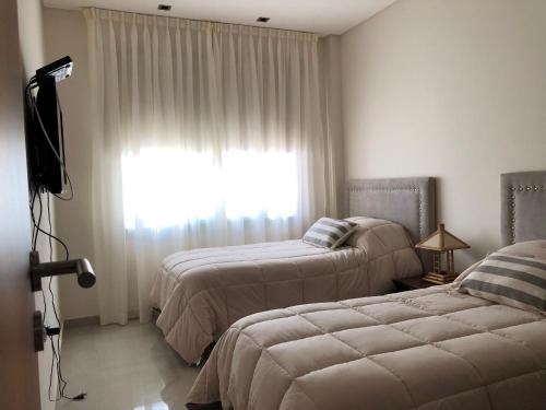 1 dormitorio con 2 camas y una ventana con cortinas en MENDOZA - CHACRAS DE CORIA - Bodegas, Viñedos, Valles en Mendoza