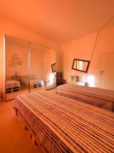a hotel room with two beds with orange walls at Bau!House in Piombino