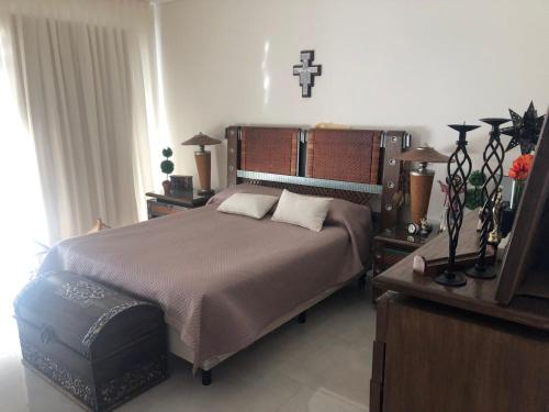 1 dormitorio con 1 cama y 1 cruz en la pared en MENDOZA - CHACRAS DE CORIA - Bodegas, Viñedos, Valles en Mendoza