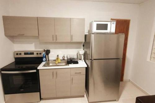 a kitchen with a stainless steel refrigerator and a microwave at Cozy Apt near Pinero Train Stop in San Juan