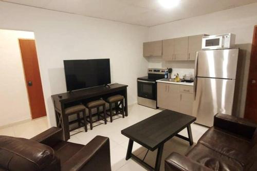 a kitchen with a stainless steel refrigerator and a table at Cozy Apt near Pinero Train Stop in San Juan