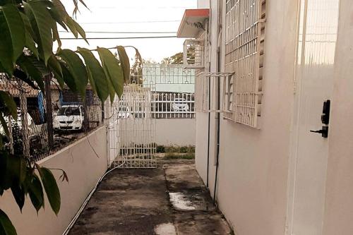 an alley with a white fence in a building at Cozy Apt near Pinero Train Stop in San Juan