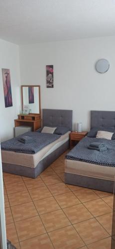 - 2 lits dans une chambre avec 2 tables dans l'établissement Penzion Forest, à Rozvadov