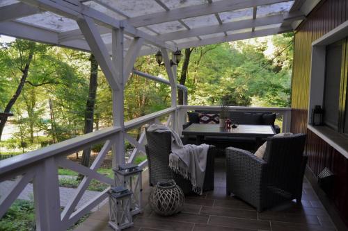 a screened in porch with a table and chairs at Irma-forrás Vendégházak - Kisház in Verőce