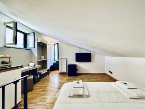 a large white room with a bed and a tv at Eterea Charming Suites in Sorrento
