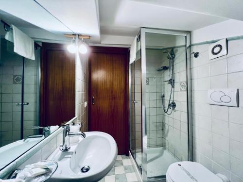 a bathroom with a sink and a shower and a toilet at Eterea Charming Suites in Sorrento
