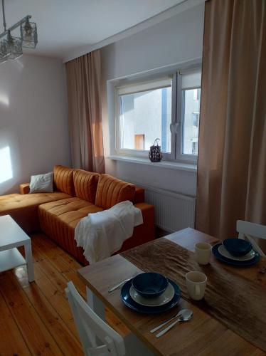 ein Wohnzimmer mit Sofa und Tisch in der Unterkunft Tabago Studio 8 in Oppeln