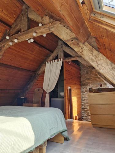une chambre avec un lit dans un grenier dans l'établissement Gite rustique en Centre Bretagne, à Laniscat