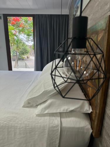 a bedroom with a bed with a black cage light on it at Apartamentos Finca Wapa in Frontera