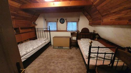1 Schlafzimmer mit 2 Betten im Dachgeschoss in der Unterkunft Chalupa pod Modřínem in Kořenov