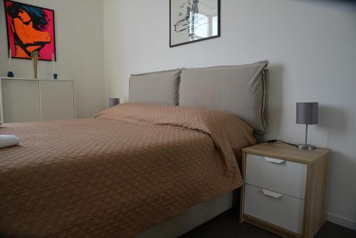 - une chambre avec un lit et une table avec une lampe dans l'établissement Casa Mameli - Pesaro Centro/Mare, à Pesaro