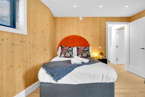 ein Schlafzimmer mit einem großen Bett und Holzwänden in der Unterkunft Green Mews 3 with Free Parking - By My Getaways in Brighton & Hove