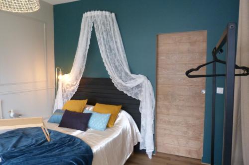 une chambre avec un lit à baldaquin dans l'établissement Le cocon des Ancelyns, au Teich