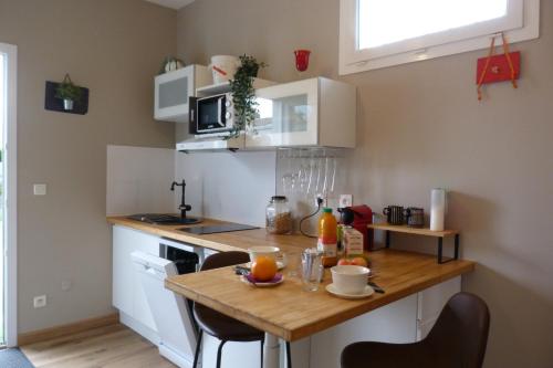 - une cuisine avec une table en bois et des fruits dans l'établissement Le cocon des Ancelyns, au Teich