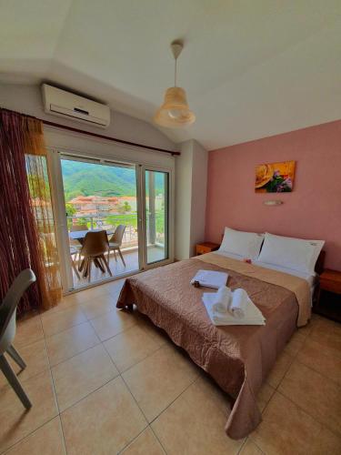 a bedroom with a large bed and a balcony at Studios Denis in Stavros