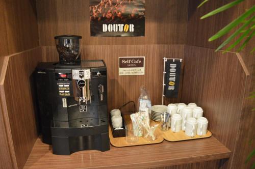 a coffee shop with a coffee maker and coffee cups at Hotel Route Inn Isehara Ooyama Inter -Kokudo 246 Gou- in Isehara