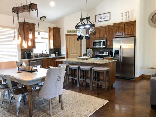聖馬科斯的住宿－SpecialTies Cottage，一间带桌椅的厨房和一间带冰箱的厨房