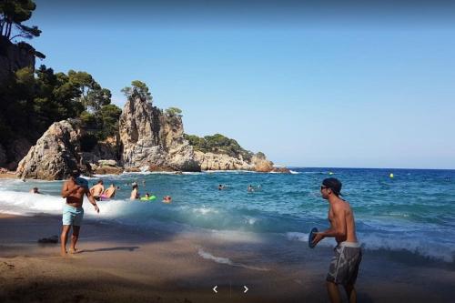 two people playing with a frisbee on the beach at Appartement tout confort avec WIFI vue sur mer et piscine communautaire secteur EL GOLFET à Callela de Palafrugell in Palafrugell