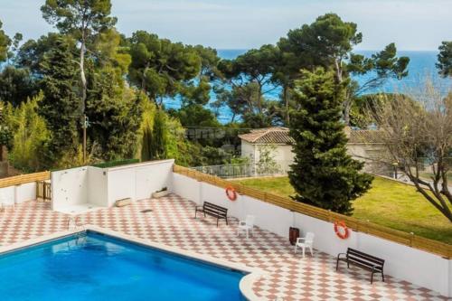 a swimming pool with a view of a house at Appartement tout confort avec WIFI vue sur mer et piscine communautaire secteur EL GOLFET à Callela de Palafrugell in Palafrugell