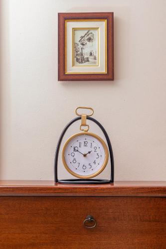 a clock sitting on top of a wooden dresser at Apartments Saxo in Kotor
