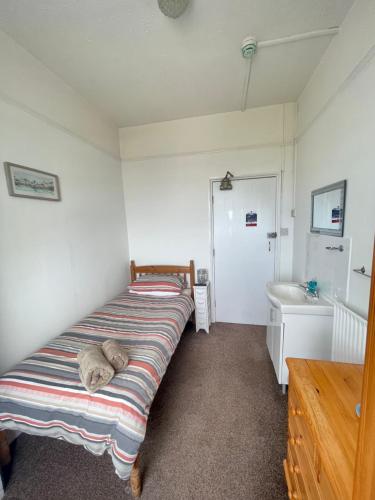 a bedroom with a bed and a sink at Bon-Ami in Lowestoft