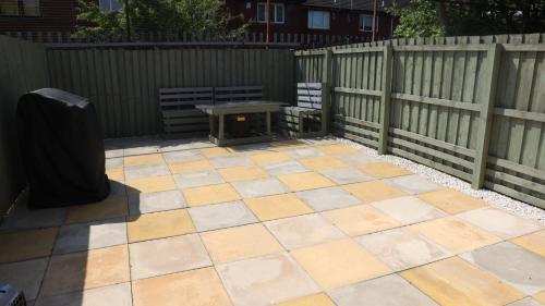 a patio with a table and a fence at Urban Escape Glasgow Green Free Parking 20min walk to City Center in Glasgow
