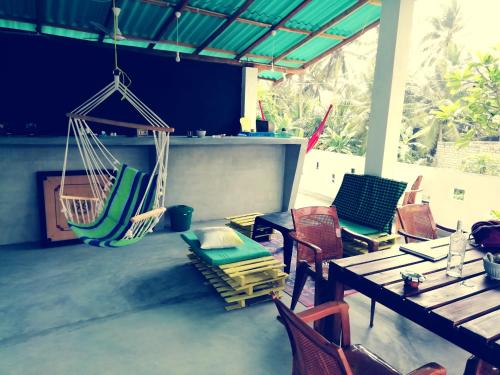 a room with chairs and a table and swings at Tiger Villa in Midigama East
