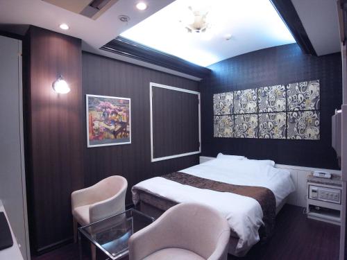 姫路市にあるホテル カルネヴァール 男塾ホテルグループのベッドルーム1室(ベッド1台、椅子2脚付)