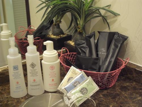 a bathroom counter with bottles of lotion and money at ホテル カルネヴァール 男塾ホテルグループ in Himeji